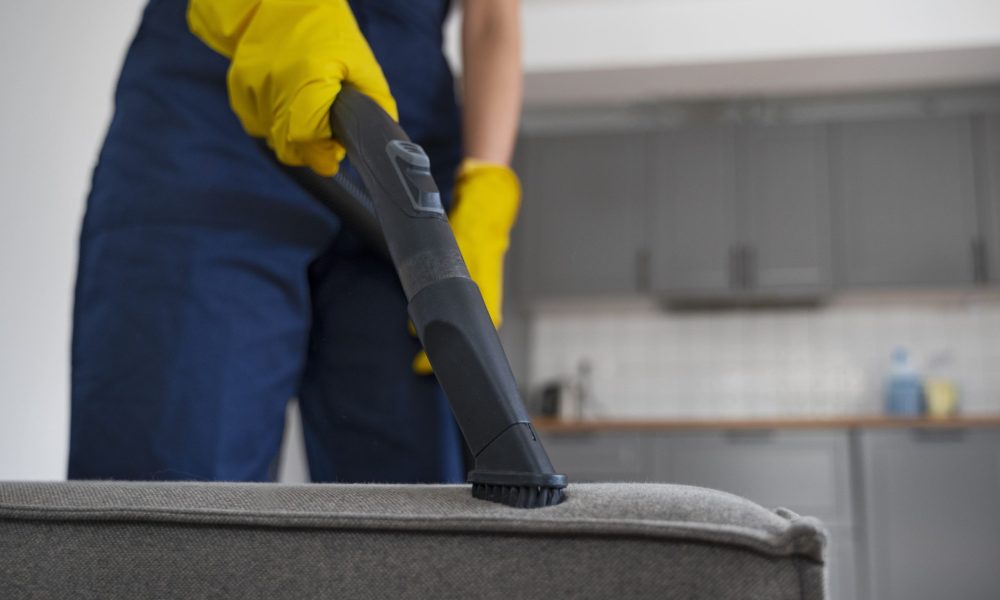 Nettoyage d'un canapé en tissu avec un aspirateur par un professionnel.